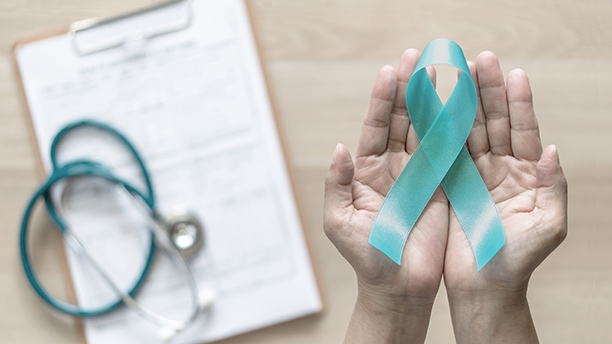 Teal ribbon awareness on woman's hand for Ovarian Cancer